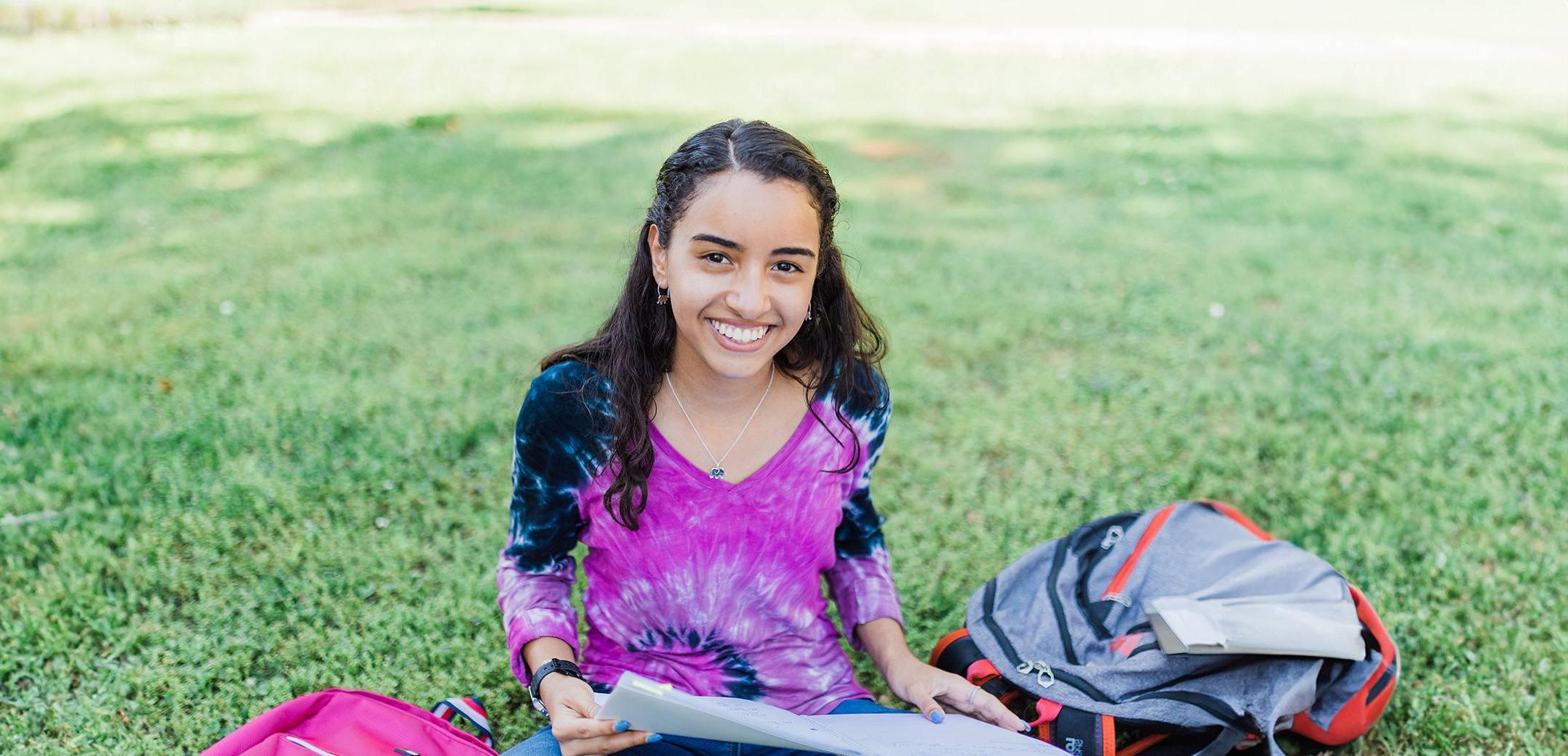 girl smiling seated on grass