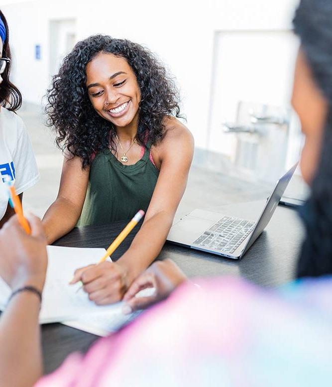 smiling female student outside with notebook