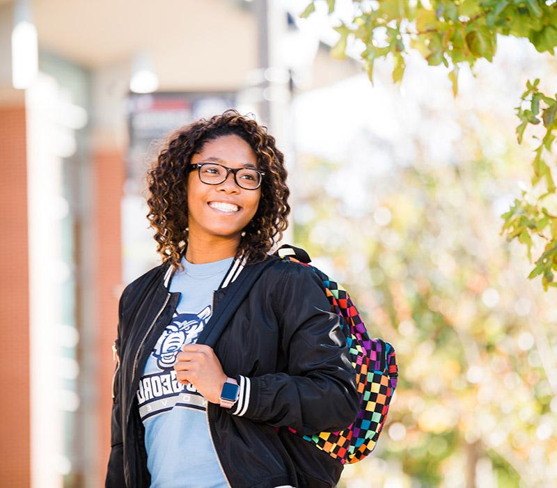 student outdoors smiling